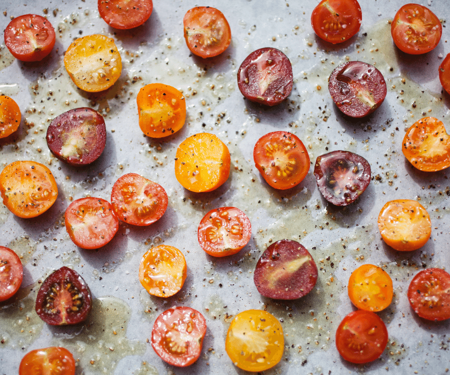 Roasted Cherry Tomatoes on a baking tray with seasoning
